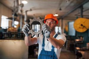 em mãos alongadas. homem de uniforme trabalha na produção. tecnologia industrial moderna foto