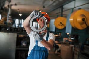 forma perfeita. homem de uniforme trabalha na produção. tecnologia industrial moderna foto