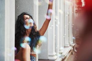 vida em cores. mulher bonita com cabelo preto encaracolado se diverte na cidade durante o dia foto