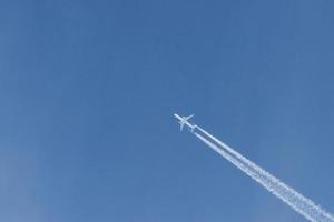 avião moderno voando alto no céu azul em dia ensolarado. velocidade e energia foto
