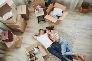 descansando. deitado no chão. casal jovem alegre em seu novo apartamento. concepção de movimento foto