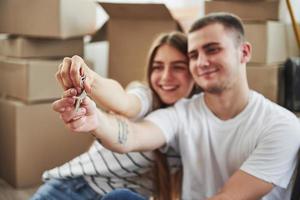 detém as chaves de sua nova casa. pessoas bem sucedidas. casal jovem alegre em seu novo apartamento. concepção de movimento foto