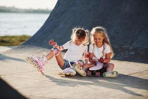 relaxar e conversar. na rampa para esportes radicais. duas meninas com patins ao ar livre se divertem foto