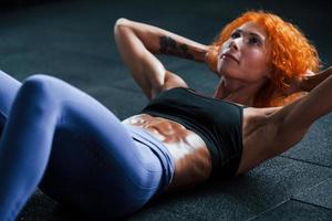 menina ruiva desportiva tem dia de fitness no ginásio durante o dia. tipo de corpo musculoso foto