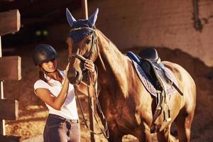 animal está com roupas azuis. amazona de uniforme e capacete protetor preto com seu cavalo foto