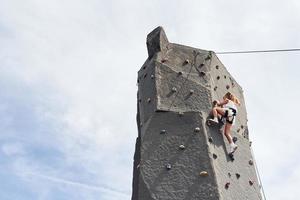 menina em roupas brancas casuais treinando escalada ao ar livre foto