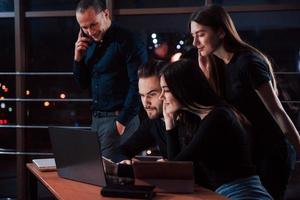 um pouco e estaremos no topo. equipe de jovens empresários trabalha em seu projeto à noite no escritório foto