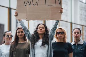 com uma tabuleta nas mãos. grupo de mulheres feministas protestam por seus direitos ao ar livre foto