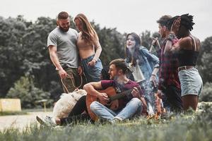 ao lado da mata. grupo de pessoas faz piquenique na praia. amigos se divertem no fim de semana foto