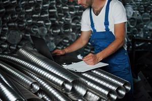 jovem engenheiro. homem de uniforme trabalha na produção. tecnologia industrial moderna foto