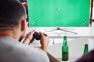 grupo de amigos se diverte jogando jogo de console dentro de casa na sala de estar foto