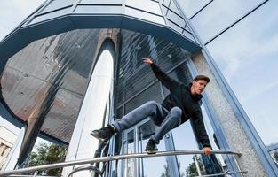 jovem fazendo parkour na cidade durante o dia. concepção de esportes radicais foto