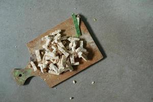 comida indonésia, tempeh cru cortado em quadrados em um fundo de concreto foto