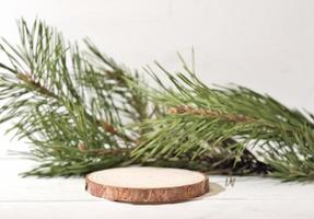 pódio natural de madeira com decoração de galho de pinheiro, exibição de produto moderna mínima. pedestal de corte de serra, vitrine de palco de cena vazia para novo produto, promoção de venda foto