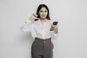 uma mulher asiática desapontada vestindo camisa branca dá polegares para baixo gesto de desaprovação, isolado pelo fundo branco foto