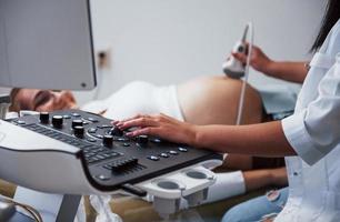 médica feminina faz ultrassom para uma mulher grávida no hospital foto