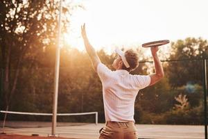 jovem tenista em roupas esportivas está na quadra ao ar livre foto