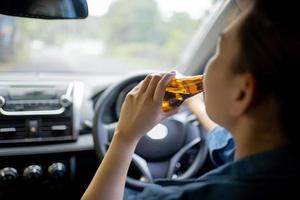mulher asiática bebendo cerveja e bebidas alcoólicas enquanto dirige, ela foi irresponsável não respeitou a lei beber e dirigir arriscando acidentes