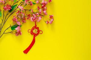 pingente de suspensão para ornamento de ano novo chinês significado da palavra é riqueza com flores chinesas em fundo amarelo. foto