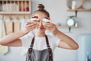 mulher fica dentro de casa na cozinha com torta caseira foto