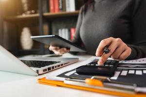 negócios trabalhando no escritório de mesa com o uso de uma calculadora para calcular os números, conceito de contabilidade financeira foto