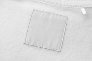 etiqueta de roupas de lavanderia branca em branco no fundo de textura de tecido foto