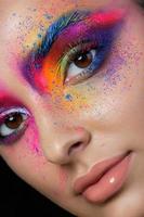 close-up vista do rosto feminino com maquiagem de moda multicolorida brilhante