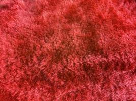 textura de tecido de lã vermelha usada como plano de fundo. fundo de tecido vermelho vazio de material têxtil macio e liso. há espaço para o texto. foto
