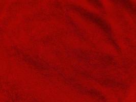 textura de tecido de veludo vermelho escuro usada como plano de fundo. fundo de tecido vermelho escuro vazio de material têxtil macio e liso. há espaço para o texto.. foto