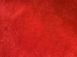 textura de tecido de veludo vermelho escuro usada como plano de fundo. fundo de tecido vermelho escuro vazio de material têxtil macio e liso. há espaço para o texto.. foto