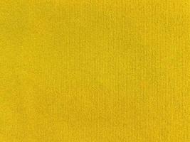 textura de tecido de veludo amarelo usada como plano de fundo. fundo de tecido amarelo vazio de material têxtil macio e liso. há espaço para o texto. foto