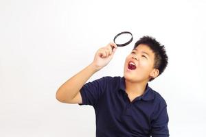 menino segurando uma lupa sobre fundo branco. conhecimento, pesquisar e explorar o conceito. foto