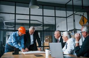 equipe envelhecida de arquitetos empresários idosos tem uma reunião no escritório foto