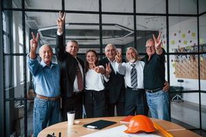 equipe envelhecida de arquitetos empresários idosos fica no escritório junto com a jovem foto