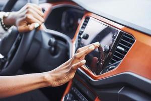 close-up vista das mãos da mulher afro-americana dentro do novo carro moderno