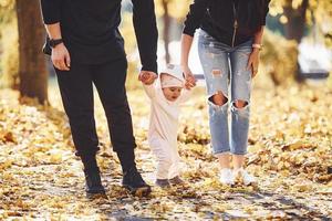 vista de perto. família alegre se divertindo junto com seu filho no belo parque outono foto