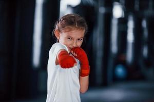 retrato de menina em roupas esportivas que está na academia tem dia de exercício. concepção de boxe foto