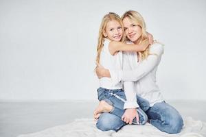 proximidade das pessoas. mãe com sua filha juntos no estúdio com fundo branco foto