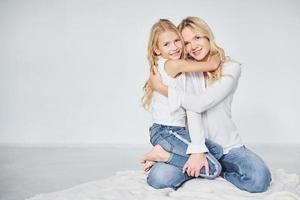 proximidade das pessoas. mãe com sua filha juntos no estúdio com fundo branco foto