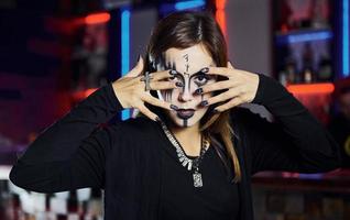retrato de mulher que está na festa temática de halloween em maquiagem e fantasia assustadora foto