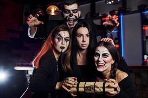 mostrando bomba. amigos está na festa temática de halloween em maquiagem e fantasias assustadoras foto