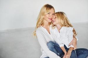 mãe com sua filha se divertem juntos no estúdio com fundo branco foto