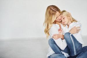 mãe com sua filha se divertem juntos no estúdio com fundo branco foto