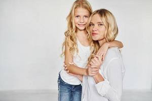 mãe com sua filha se divertem juntos no estúdio com fundo branco foto