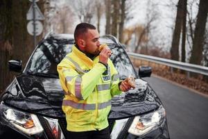 policial masculino de uniforme verde fazendo uma pausa com rosquinha na estrada