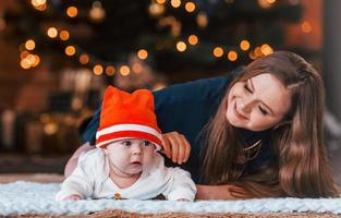 mãe com seu filho juntos no quarto decorado de natal foto