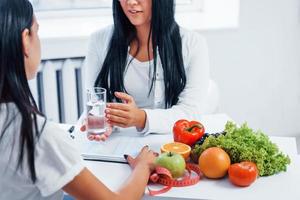 nutricionista feminina dá consulta ao paciente dentro de casa no escritório foto