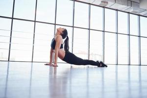 jovem mulher desportiva em roupas esportivas fazendo fitness no ginásio foto