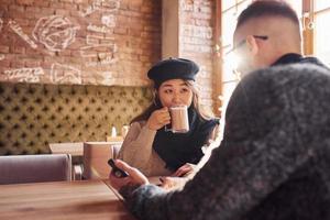 casal multirracial conversando no café. menina asiática com seu namorado caucasiano foto
