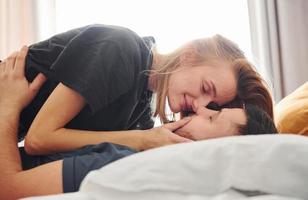 jovem casal se beijando no quarto durante o dia foto